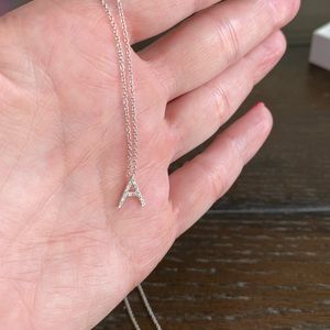 Dainty white gold initial A necklace with pave diamonds.